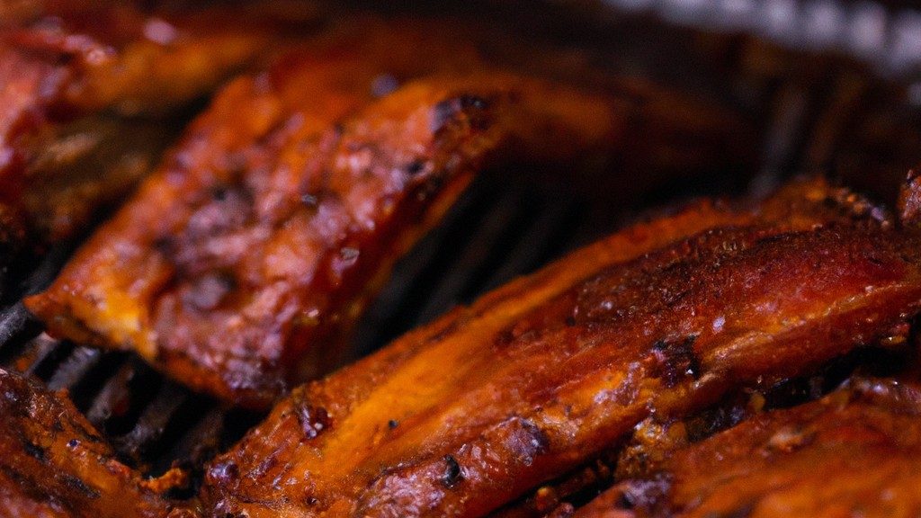 Imagem de costela assada na Airfryer, coberta com molho barbecue. A costela é suculenta e tenra, com uma crosta crocante. O molho barbecue é doce e picante, complementando perfeitamente o sabor da costela.