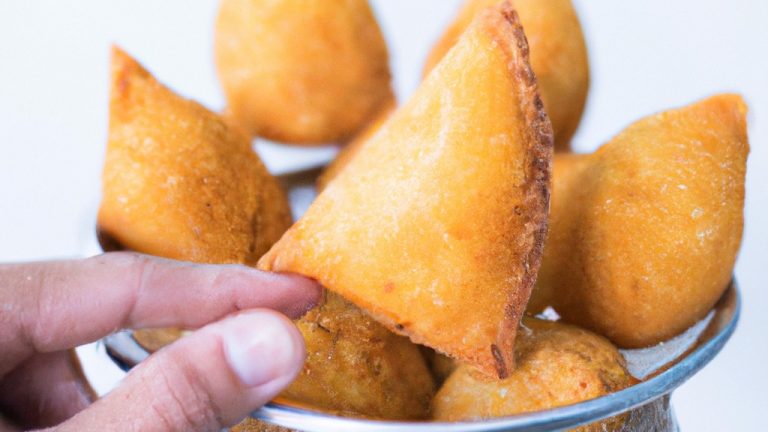 Imagem de uma coxinha de asa frita ao ar com batata frita, servida em um prato com um lado de molho. A coxinha de asa é crocante e dourada, e a batata frita é fina e crocante.
