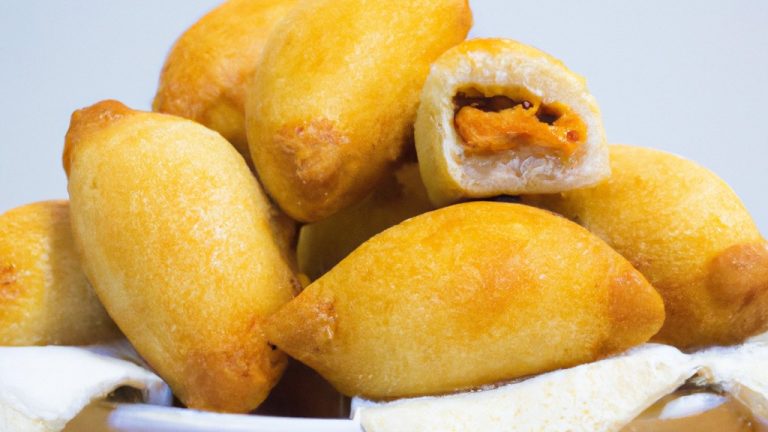 Imagem de coxinha de pão de forma empanada e frita, com frango desfiado e catupiry no interior. O prato é preparado na airfryer, o que resulta em uma textura crocante e dourada.