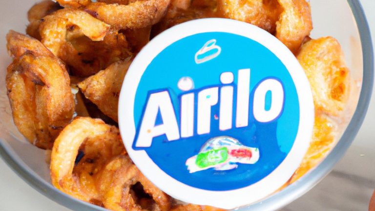 Fotografia de uma porção de crispy de alho-poró em um prato, recém-saído da airfryer. Os palitos crocantes são dourados e polvilhados com ervas frescas.