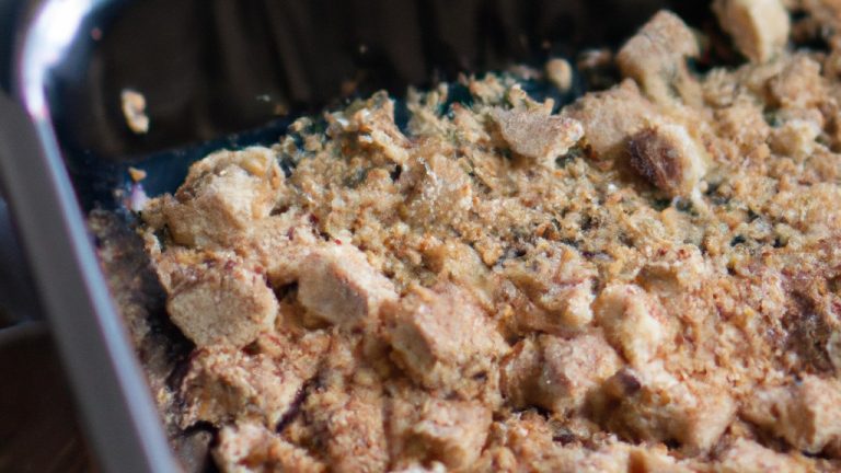 Foto de crumble de banana em ramequins na Airfryer. A cobertura crocante de paçoca é dourada e crocante, contrastando com o recheio de banana macia e caramelizada. O fundo da Airfryer é visível, indicando que o crumble foi cozido neste aparelho.