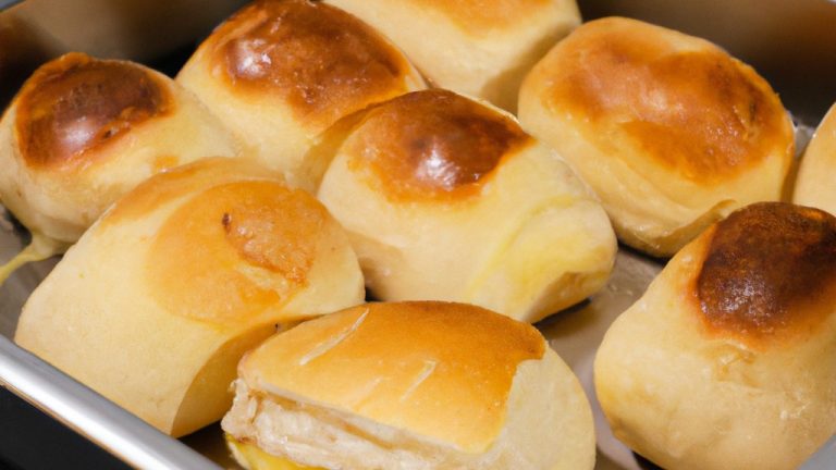 Imagem de um pão francês cortado ao meio, recheado com ovos mexidos e queijo derretido, cozido em uma airfryer. O pão está dourado e crocante, com o ovo e o queijo derretidos e borbulhando.