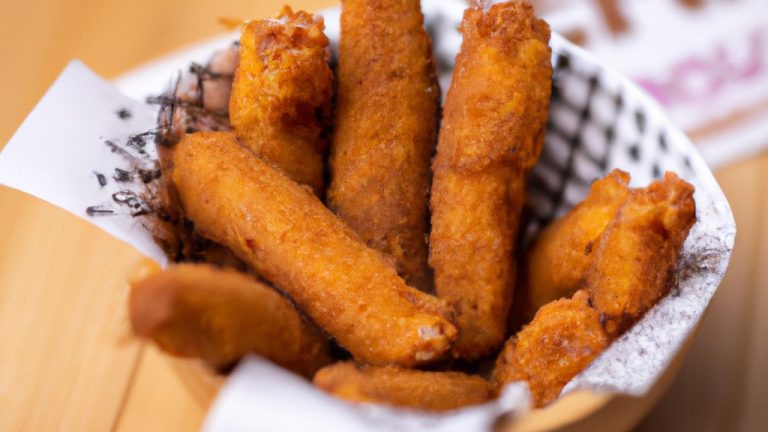 Imagem de um empanado de peixe frito na Airfryer, servido com limão e salsa. O empanado é dourado e crocante, e o peixe é branco e escamoso.