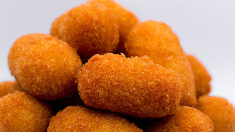 Imagem de um prato de Drumet de frango crocante cozido em uma Airfryer, acompanhado de batatas fritas e molho.