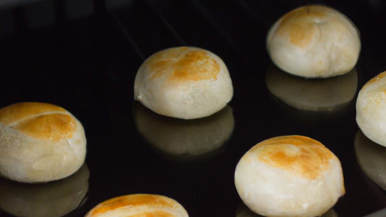 Foto aérea de uma empadinha dourada e crocante recém-saída da Airfryer. A empadinha tem uma crosta escamosa e um recheio cremoso e fumegante, visível através de um pequeno orifício na parte superior.