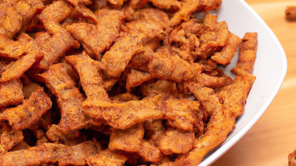Imagem de um prato de escondidinho de carne seca feito na Airfryer. A camada superior é de purê de mandioca cremoso, enquanto a camada inferior é composta por carne seca desfiada cozida em um molho rico e saboroso. O escondidinho está gratinado com queijo parmesão derretido.