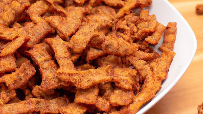 Imagem de um prato de escondidinho de carne seca feito na Airfryer. A camada superior é de purê de mandioca cremoso, enquanto a camada inferior é composta por carne seca desfiada cozida em um molho rico e saboroso. O escondidinho está gratinado com queijo parmesão derretido.