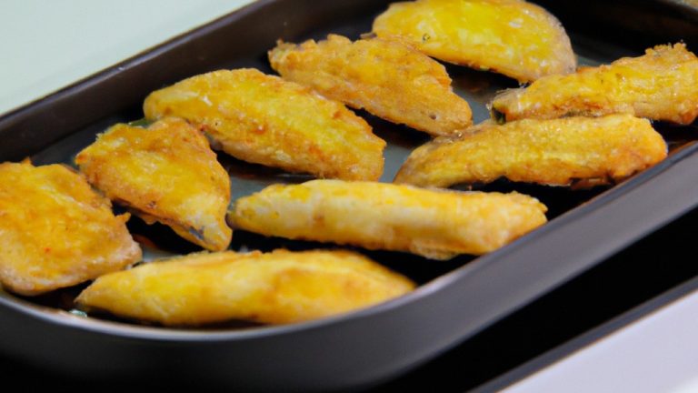 Um prato de filetes de peixe empanados dourados e crocantes, cozidos em uma Airfryer. Os filetes são colocados sobre uma cama de batatas fritas crocantes e polvilhados com limão fresco e salsa.