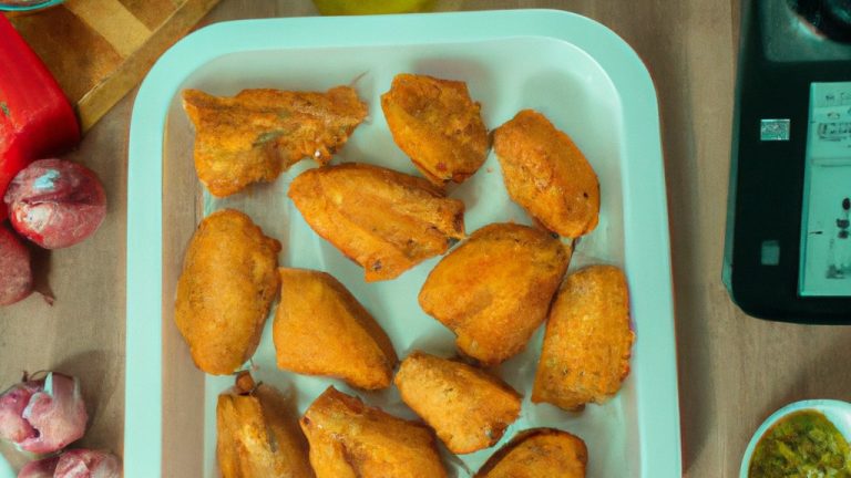 Imagem de filés de frango empanados e temperados com limão e pimenta em uma cesta de uma Airfryer.