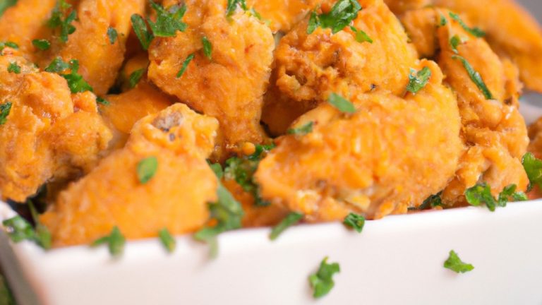 Imagem de um frango empanado dourado e crocante cozido em uma airfryer. O frango é empanado com uma crosta crocante e temperado com especiarias.