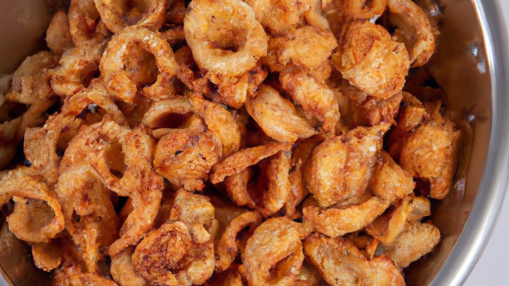 Imagem de uma tigela cheia de grãos crocantes cozidos na Airfryer. Os grãos são dourados e crocantes, com uma textura leve e arejada. Eles são perfeitos para um lanche saudável ou como acompanhamento de uma refeição.
