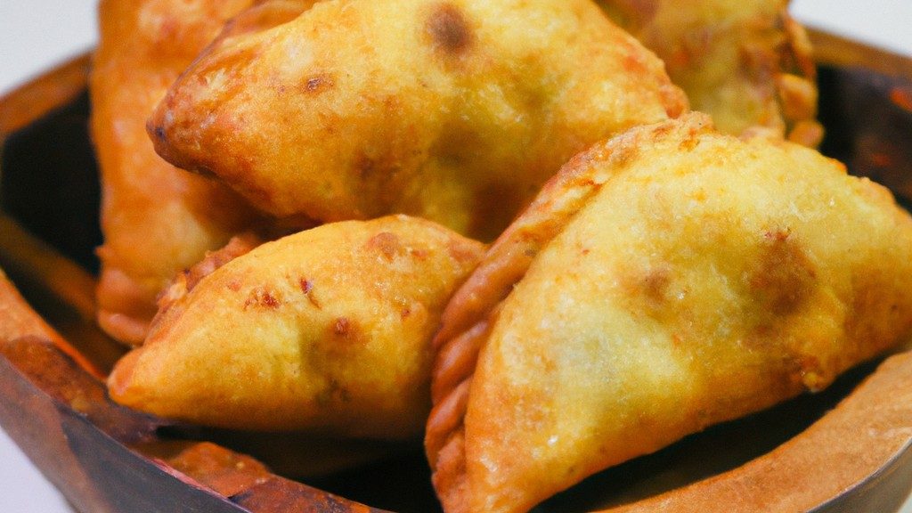 Imagem de guiozas crocantes e douradas cozidas na Airfryer. As guiozas têm uma crosta crocante e um recheio suculento, visível através das dobras da massa. Elas são dispostas em um prato branco, prontas para serem servidas com um molho de acompanhamento.