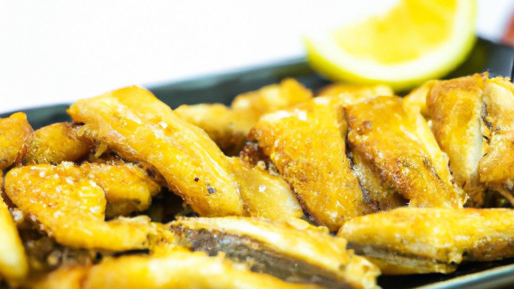 Imagem de uma travessa com iscas de peixe fritas na Airfryer. As iscas são douradas e crocantes, e estão dispostas sobre um papel toalha para absorver o excesso de óleo.