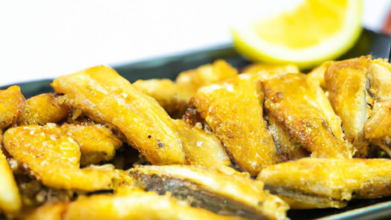 Imagem de uma travessa com iscas de peixe fritas na Airfryer. As iscas são douradas e crocantes, e estão dispostas sobre um papel toalha para absorver o excesso de óleo.