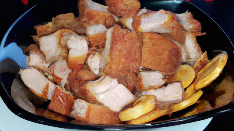 Imagem de Joelhos de Porco crocantes e dourados cozidos em uma Airfryer. A imagem mostra o prato em um prato, acompanhado de vegetais grelhados.
