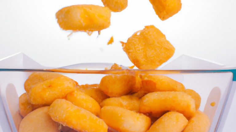 Imagem de uma porção de estalinhos de queijo em uma tigela, feitos na airfryer. Os palitos são dourados e crocantes, com uma textura fofa por dentro. Eles são servidos com um molho de tomate para mergulhar.