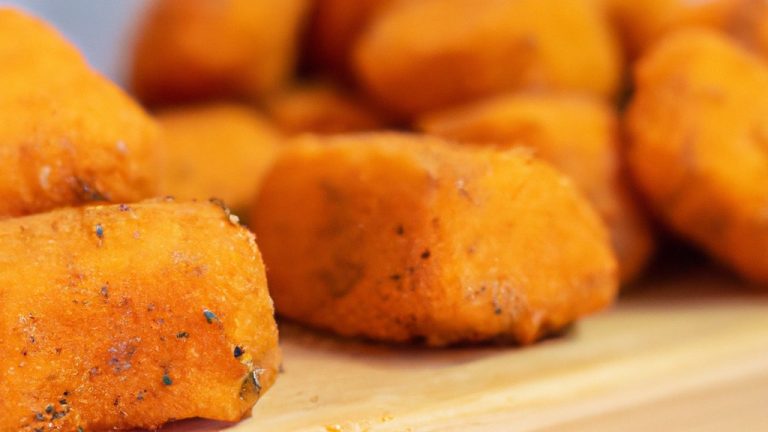 Foto de laranjas fatiadas desidratadas em uma Airfryer. As fatias são de cor laranja brilhante e têm uma textura enrugada. Elas estão dispostas em uma única camada na cesta da Airfryer.