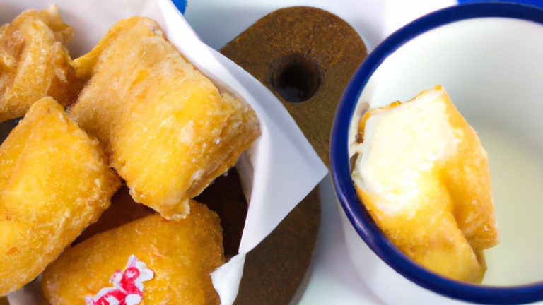 Imagem do alto de uma travessa redonda de vidro refratário transparente contendo leite condensado com coco feito na airfryer. A sobremesa possui uma superfície dourada e cremosa, com uma consistência espessa e apetitosa. O fundo da travessa é visível, mostrando a textura crocante e caramelizada do leite condensado.