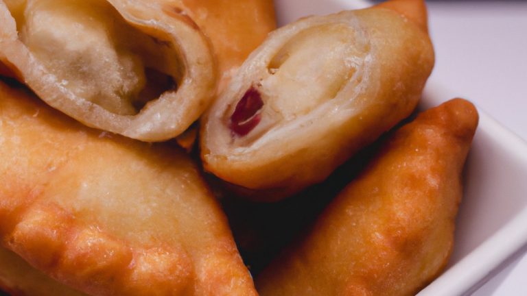 Imagem de empanadas de mandioca preparadas em uma Airfryer, com recheio dourado e crosta crocante. Essas empanadas são uma receita fácil e deliciosa, perfeita para um lanche ou refeição rápida.