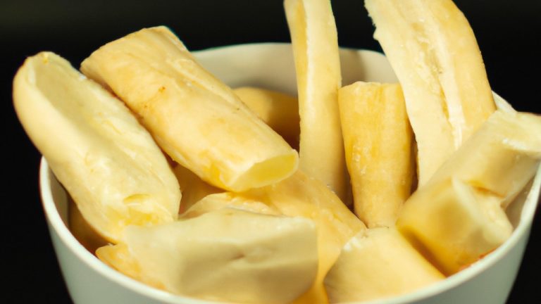 Imagem de mandioca frita em uma Airfryer. A mandioca está cortada em palitos e tem uma cor dourada crocante. Ela está disposta em uma cesta de Airfryer e o fundo é visível.