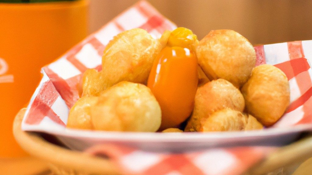 Imagem de mandioquinhas cortadas em rodelas e colocadas na cesta da Airfryer. O fundo é branco e o texto "Mandioquinha Na Airfryer: Receita Fácil De Fazer, Aprenda Já!" está escrito em vermelho na parte superior.