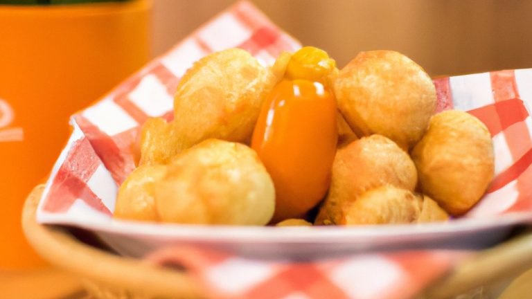 Imagem de mandioquinhas cortadas em rodelas e colocadas na cesta da Airfryer. O fundo é branco e o texto "Mandioquinha Na Airfryer: Receita Fácil De Fazer, Aprenda Já!" está escrito em vermelho na parte superior.