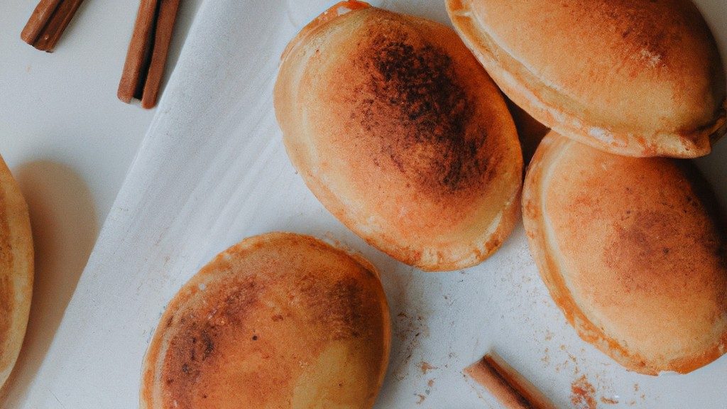 Imagem de uma massa de pastel frita na airfryer, polvilhada com açúcar e canela. A massa está dourada e crocante, e o açúcar e a canela criam uma cobertura doce e aromática.