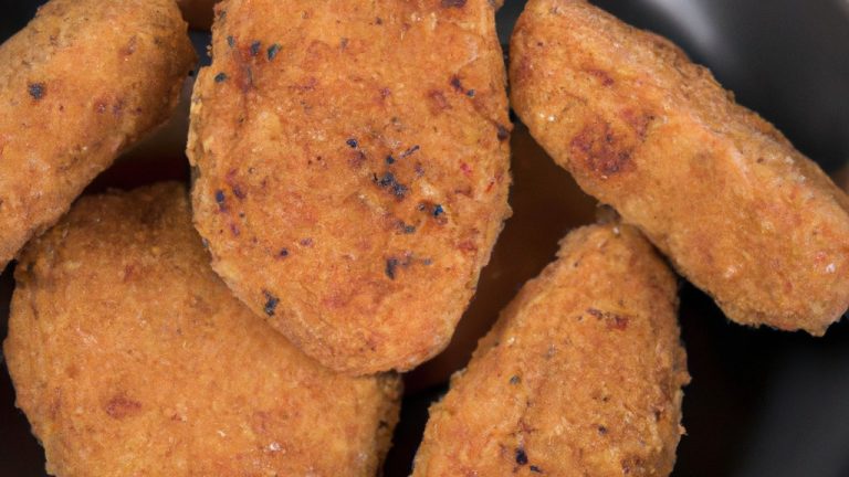 Imagem de um medalhão de alcatra dourado e crocante cozido em uma Airfryer, servido em um prato com uma guarnição de vegetais grelhados. O medalhão é suculento e macio por dentro, com uma crosta crocante e dourada por fora.