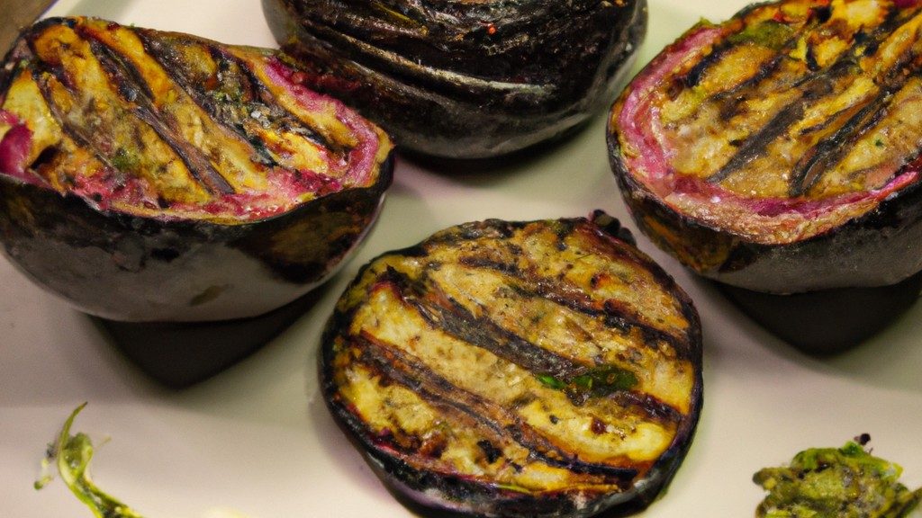Uma vista superior de um medalhão de berinjela fatiado em rodelas grossas e empanado, coberto com pesto verde. O prato está disposto em um prato branco com uma guarnição de folhas de manjericão fresco.