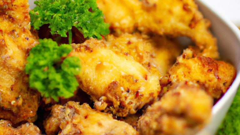 Imagem de um prato com mini filés de frango empanados fritos em uma Airfryer. Os filés são dourados e crocantes, com uma textura macia e suculenta por dentro. Eles são servidos com um molho cremoso à base de mostarda ao lado.