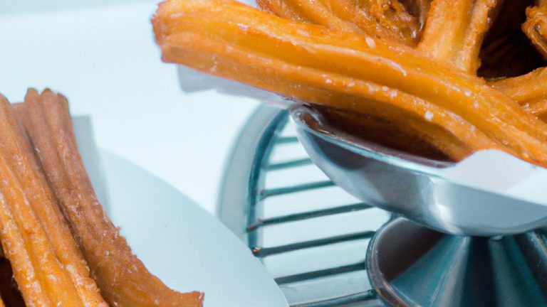 Uma foto de mini churros recém-fritos e crocantes em uma cesta forrada com papel manteiga, regados com canela e açúcar, com uma tigela de calda de chocolate ao lado.
