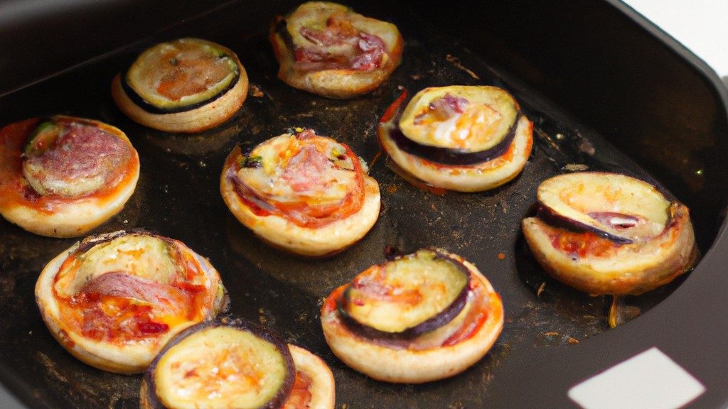 Foto de uma mini pizza de berinjela feita na Airfryer. A berinjela é cortada em fatias finas e coberta com molho de tomate, queijo e coberturas. A pizza é cozida na Airfryer até que o queijo esteja borbulhando e a berinjela esteja macia.