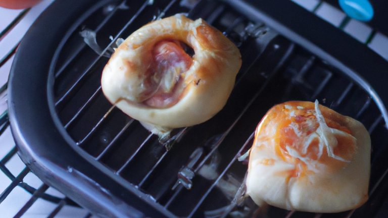 Imagem de uma mini pizza redonda cozida em uma airfryer. A pizza tem uma crosta dourada e está coberta com molho de tomate, queijo mussarela e pepperoni.