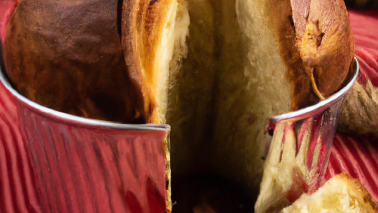 Imagem de um panetone caseiro acabado de fazer, cozido na airfryer, visto de cima. O panetone é dourado e fofo, com uvas passas e frutas cristalizadas visíveis na superfície.
