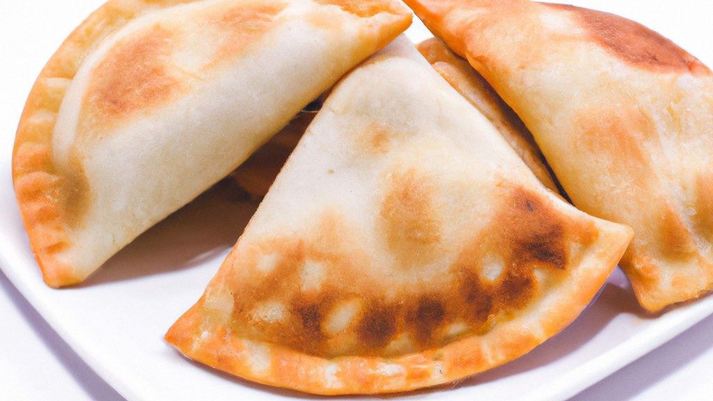 Imagem de panquecas douradas e fofas feitas com massa de pastel cozidas em uma Airfryer. As panquecas são cobertas com manteiga derretida e calda de bordo.