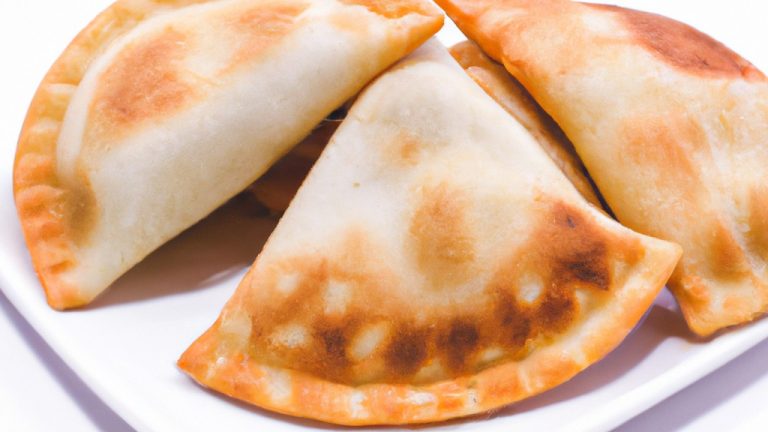 Imagem de panquecas douradas e fofas feitas com massa de pastel cozidas em uma Airfryer. As panquecas são cobertas com manteiga derretida e calda de bordo.