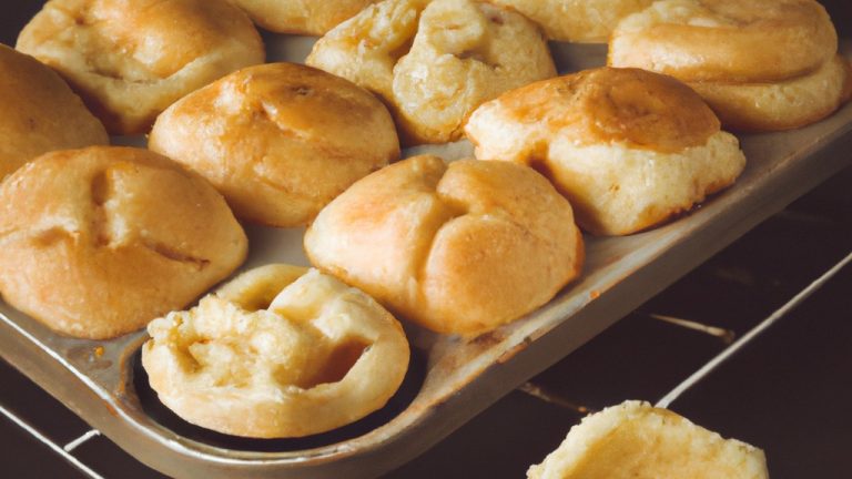 Imagem de um pão redondo dourado e crocante aberto ao meio, recheado com um cremoso e derretido catupiry. O pão está apoiado em uma cesta de vime, com alguns ramos de alecrim ao lado.