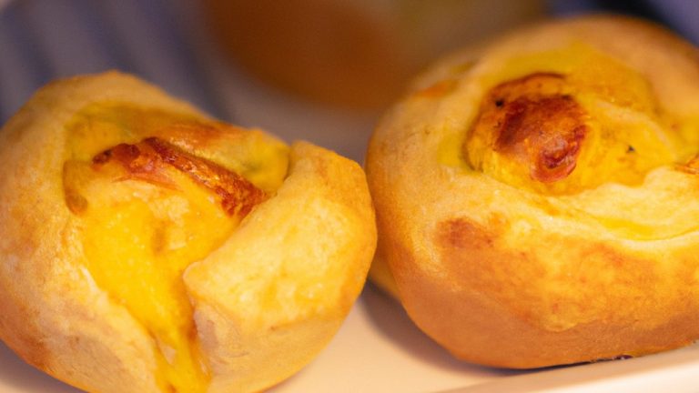Imagem de pão de forma torrado na airfryer com ovo frito e queijo derretido por cima. A fatia de pão está em um prato branco e há uma faca e um garfo ao lado dela.