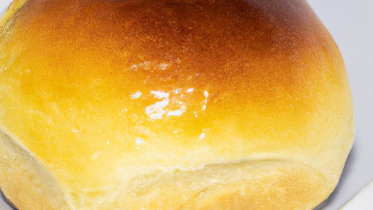 Imagem de pão de forma recheado cozido em uma airfryer. O pão é marrom dourado e tem um recheio cremoso e derretido visível.