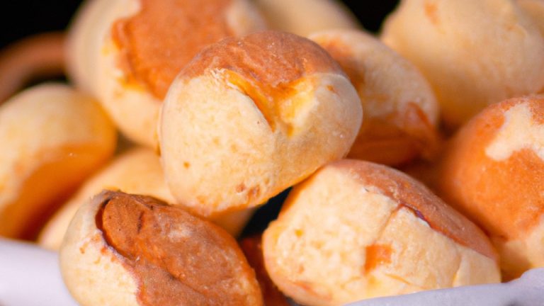 Imagem de pães de mandioca crocantes e dourados preparados na airfryer. A textura crocante e o interior macio são visíveis, com gotas de óleo brilhando na superfície.