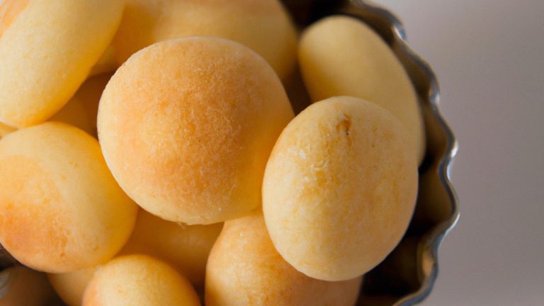 Imagem de pães de queijo de batata-doce recém-assados em uma cesta de fritadeira. Os pães de queijo são dourados e crocantes, com uma textura macia por dentro.