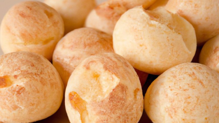 Imagem de pães de queijo dourados e crocantes em uma cesta de vime, acompanhados de um pequeno pote de mel.