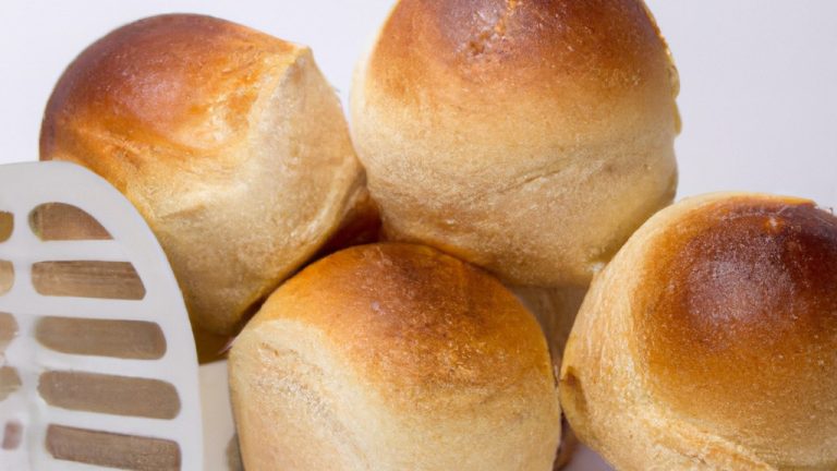 Imagem de pães dourados e crocantes recém-saídos de uma airfryer. A textura crocante do lado de fora contrasta com o interior macio e fofo, criando um pão delicioso e satisfatório.