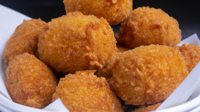 Uma foto de vários paolinhos dourados e crocantes servidos em um prato. Eles são guarnecidos com salsa fresca e limão.