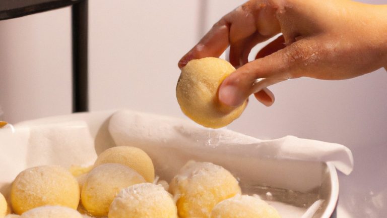 Imagem de pãozinho de tapioca crocante e dourado feito na Airfryer, mostrando sua textura porosa e formato redondo.