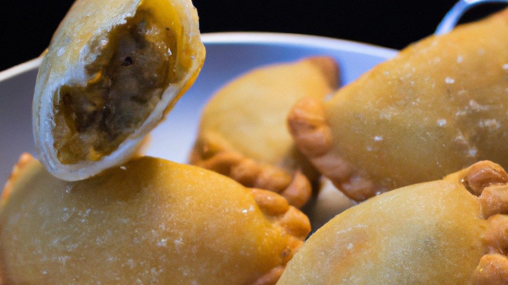 Imagem de um prato com pasteis de ricota fritos na Airfryer. Os pasteis têm formato triangular e são dourados e crocantes. Eles são recheados com um creme de ricota cremoso e polvilhados com açúcar de confeiteiro.