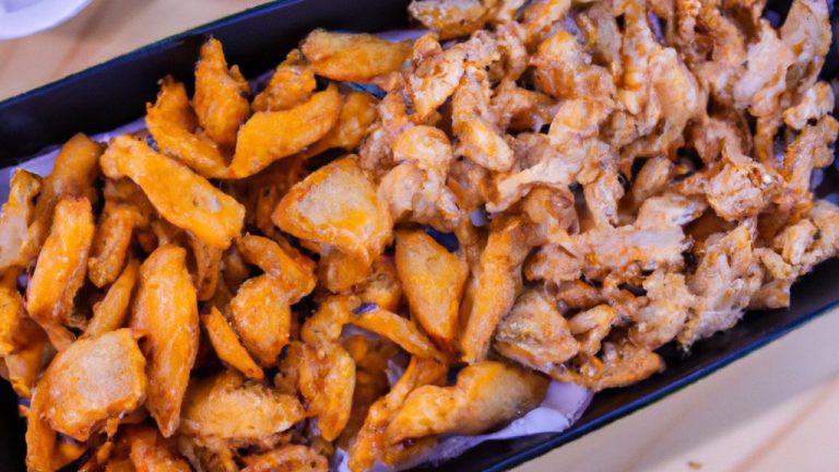 Imagem de filé de peixe empanado e assado ao lado de batatas fritas de mandioca em um prato branco.