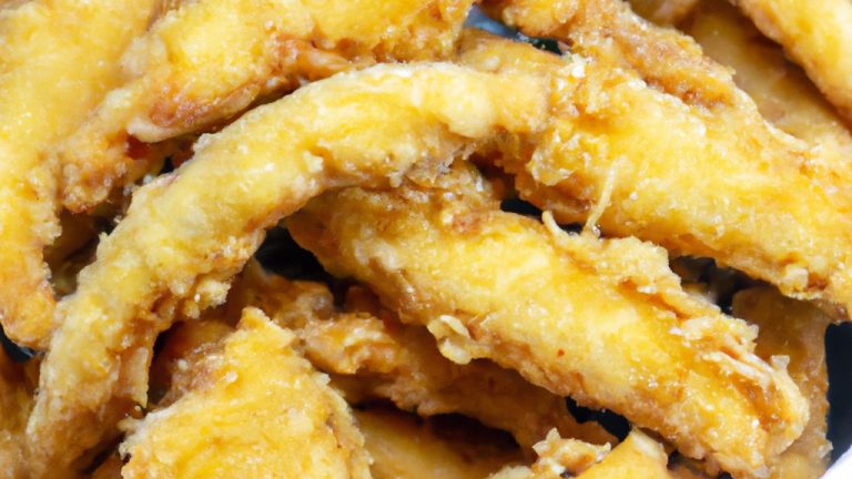 Imagem de peixe frito crocante e dourado na airfryer, com limão e ervas frescas ao lado. A imagem mostra um prato delicioso e crocante, perfeito para um jantar rápido e fácil.