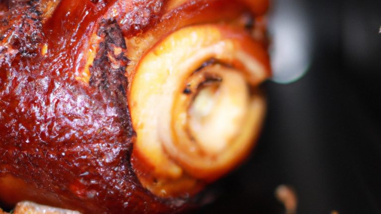 Imagem de um pernil de porco assado na Airfryer, com pele crocante e dourada. O pernil é temperado com ervas e especiarias aromáticas, o que lhe confere um sabor delicioso e suculento.