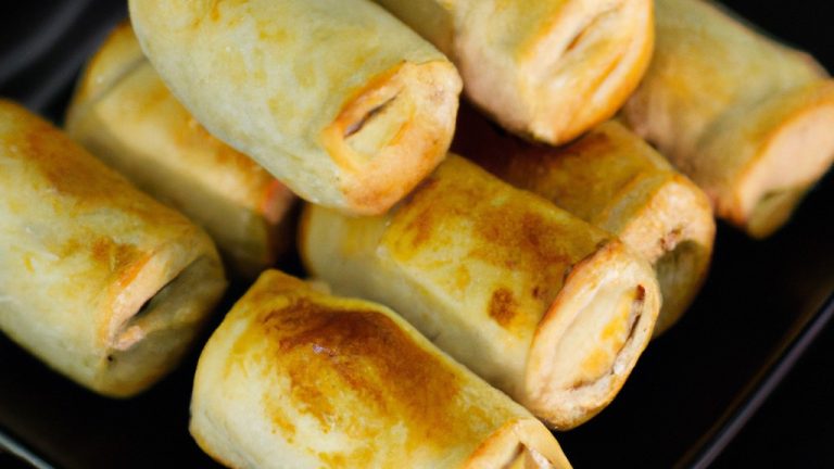 Imagem de petiscos de massa folhada assados na airfryer, crocantes e dourados, recheados com queijo, presunto e cebola.